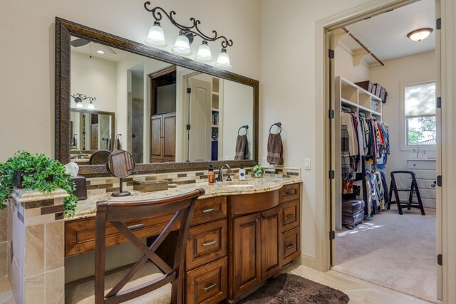 bathroom featuring tasteful backsplash, a spacious closet, and vanity