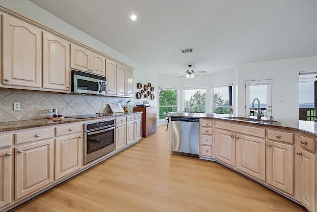 20718 Camel Back St, Lago Vista, TX 78645 - kitchen featuring stainless steel appliances, light brown cabinetry, a sink, light wood-style flooring, and decorative backsplash