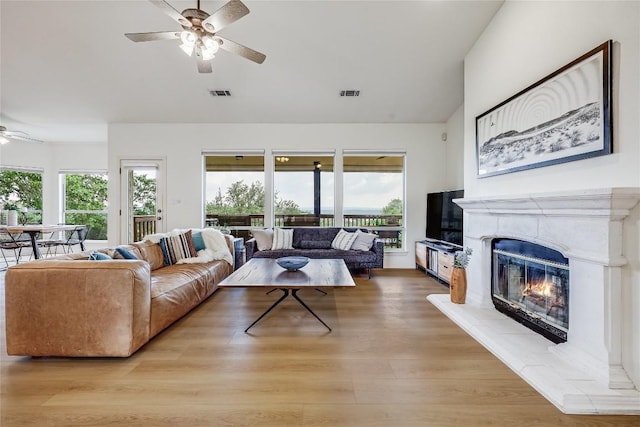 20718 Camel Back St, Lago Vista, TX 78645 - living area featuring ceiling fan, a glass covered fireplace, lofted ceiling, and light wood finished floors