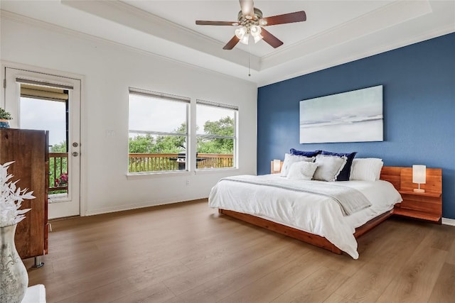 20718 Camel Back St, Lago Vista, TX 78645 - bedroom featuring a tray ceiling, access to outside, ornamental molding, wood finished floors, and baseboards