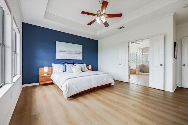 20718 Camel Back St, Lago Vista, TX 78645 - bedroom with wood finished floors, ornamental molding, a raised ceiling, ensuite bath, and baseboards