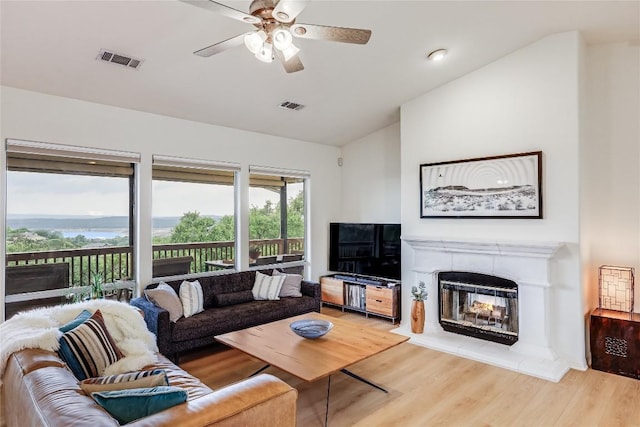 20718 Camel Back St, Lago Vista, TX 78645 - living area featuring vaulted ceiling, light wood-type flooring, a ceiling fan, a glass covered fireplace, and recessed lighting