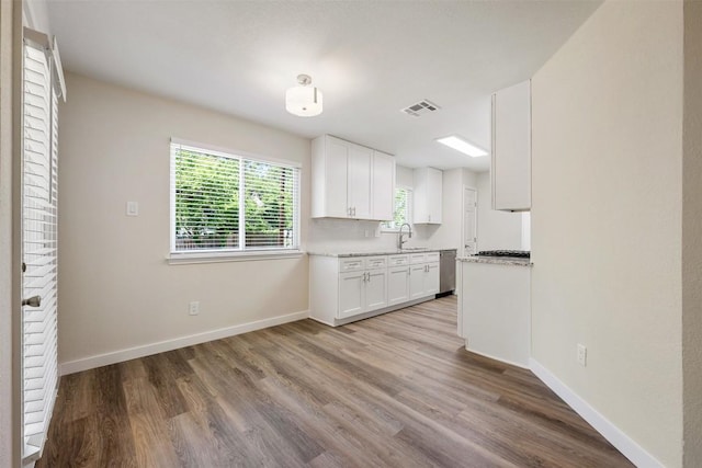 11932 Shropshire Blvd, Austin, TX 78753 - kitchen featuring white cabinetry, a sink, wood finished floors, and baseboards