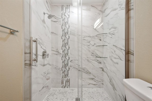bathroom featuring a shower stall, toilet, and a textured wall