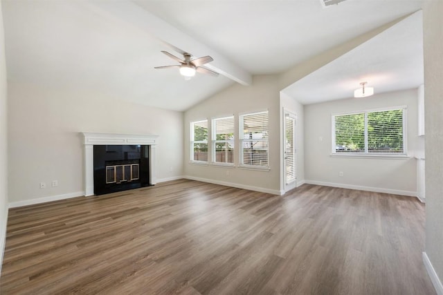 unfurnished living room featuring baseboards, wood finished floors, a wealth of natural light, and ceiling fan
