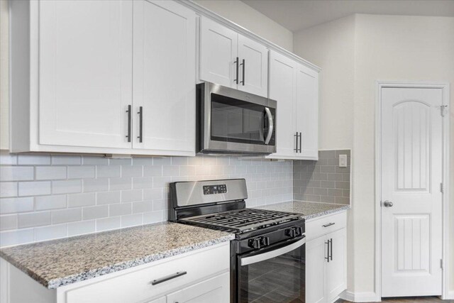 136 Medinah Ln, San Marcos, TX 78666 - kitchen featuring white cabinets, backsplash, light stone counters, and stainless steel appliances