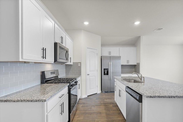 136 Medinah Ln, San Marcos, TX 78666 - kitchen featuring white cabinets, a sink, tasteful backsplash, dark wood-style flooring, and appliances with stainless steel finishes