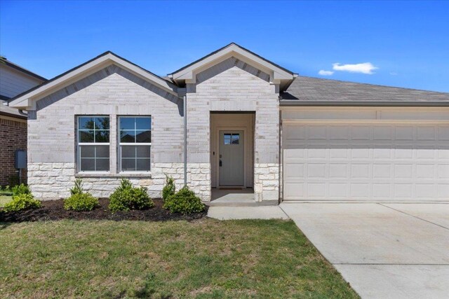 136 Medinah Ln, San Marcos, TX 78666 - ranch-style house featuring a garage, stone siding, a front lawn, and concrete driveway