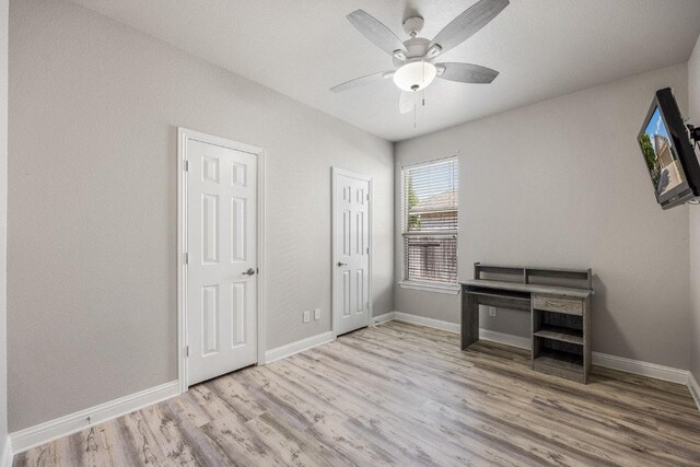 unfurnished bedroom featuring wood finished floors, a ceiling fan, and baseboards