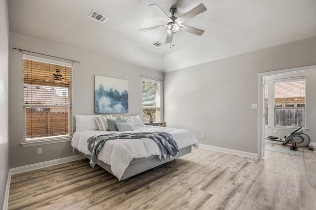 bedroom with baseboards, multiple windows, and light wood finished floors