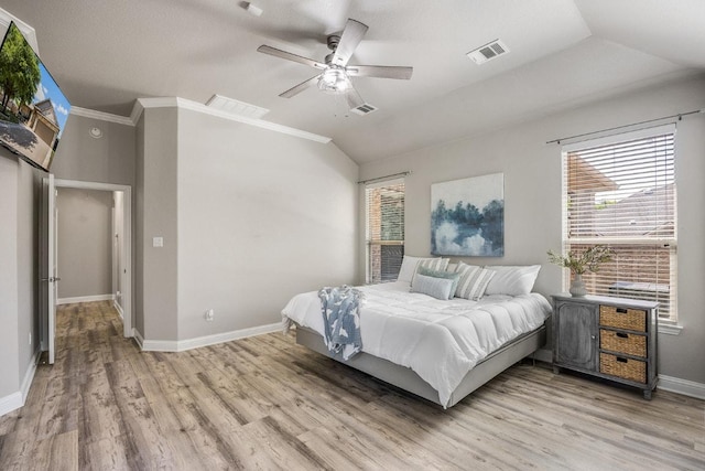 bedroom with lofted ceiling, multiple windows, visible vents, and light wood-style floors