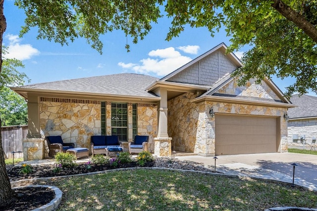 ranch-style house featuring stone siding, concrete driveway, a garage, a shingled roof, and an outdoor living space