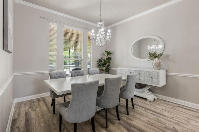 dining space with a chandelier, wood finished floors, baseboards, and ornamental molding