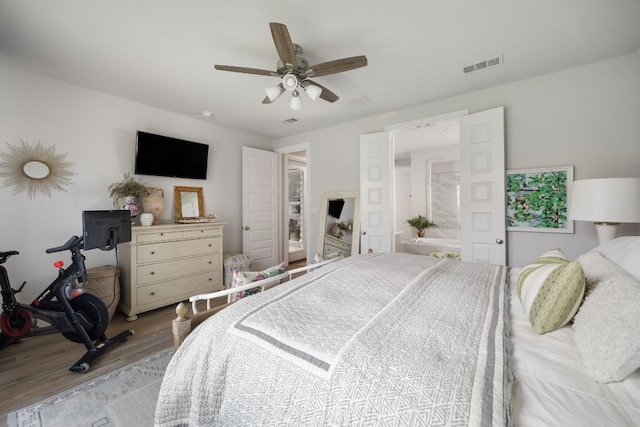 bedroom featuring wood finished floors, visible vents, and a ceiling fan