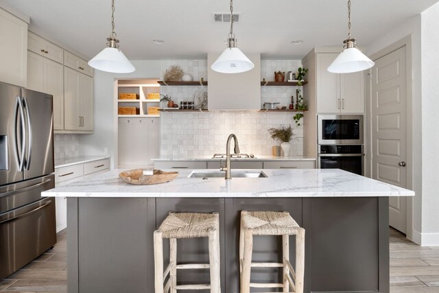 kitchen with open shelves, visible vents, decorative backsplash, light wood-style flooring, and appliances with stainless steel finishes