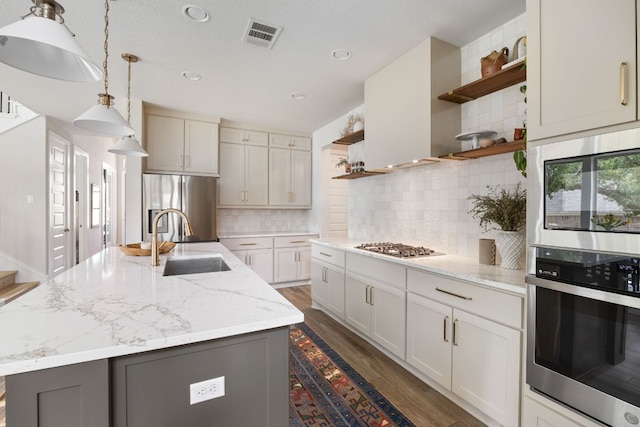 kitchen featuring a sink, open shelves, dark wood-type flooring, visible vents, and appliances with stainless steel finishes