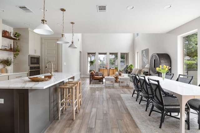 dining space featuring light wood finished floors, visible vents, and recessed lighting