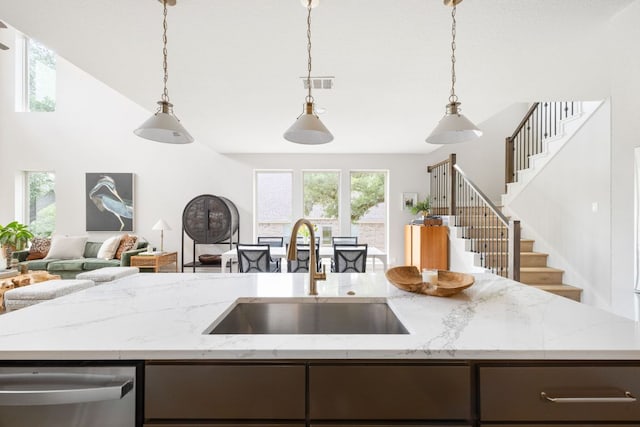 229 S Park Vis, Georgetown, TX 78628 - kitchen with a sink, stainless steel dishwasher, open floor plan, light stone counters, and pendant lighting