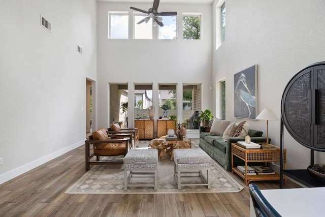 229 S Park Vis, Georgetown, TX 78628 - living area with ceiling fan, a towering ceiling, wood finished floors, and baseboards