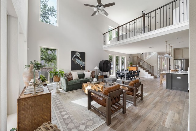 229 S Park Vis, Georgetown, TX 78628 - living room featuring a high ceiling, light wood-type flooring, stairs, and ceiling fan