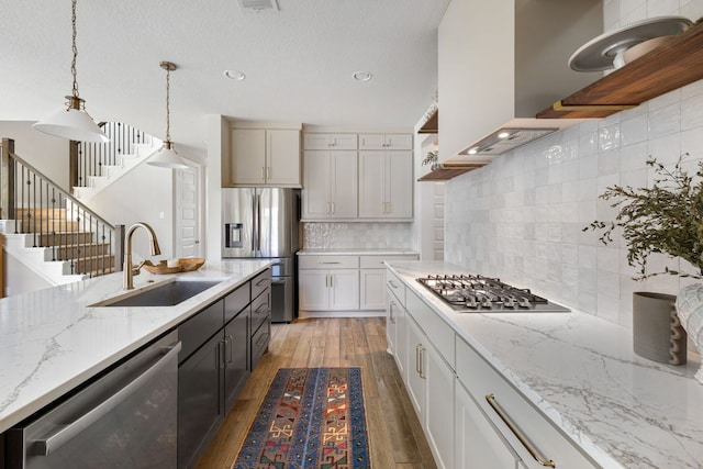 229 S Park Vis, Georgetown, TX 78628 - kitchen with a sink, stainless steel appliances, open shelves, light wood-style flooring, and decorative light fixtures