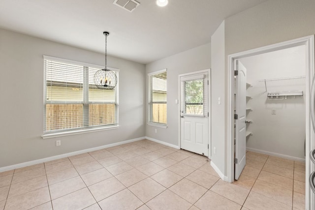 interior space with baseboards, an inviting chandelier, visible vents, and light tile patterned floors