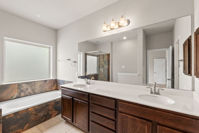 full bath with double vanity, a garden tub, a stall shower, and a sink