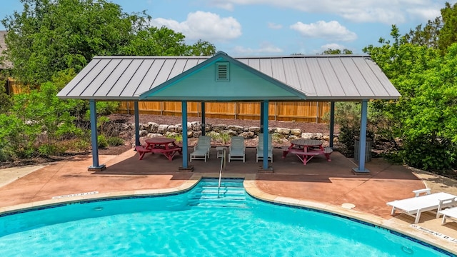 outdoor pool with a gazebo, fence, and a patio area