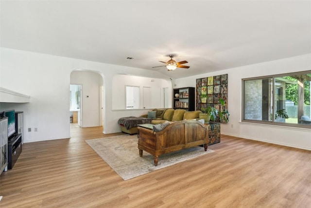 171 Calle Largo, Kyle, TX 78640 - living room with ceiling fan, arched walkways, light wood-style flooring, baseboards, and visible vents