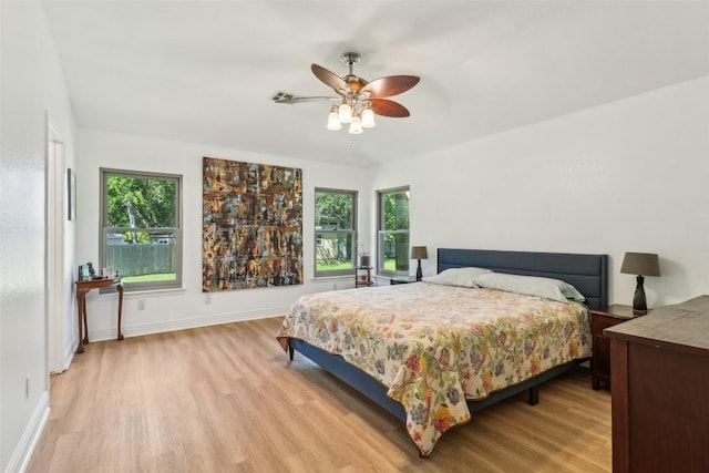 171 Calle Largo, Kyle, TX 78640 - bedroom with light wood-type flooring, a ceiling fan, baseboards, and multiple windows