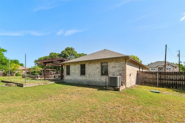 171 Calle Largo, Kyle, TX 78640 - back of property featuring a lawn, a fenced backyard, central AC, and brick siding