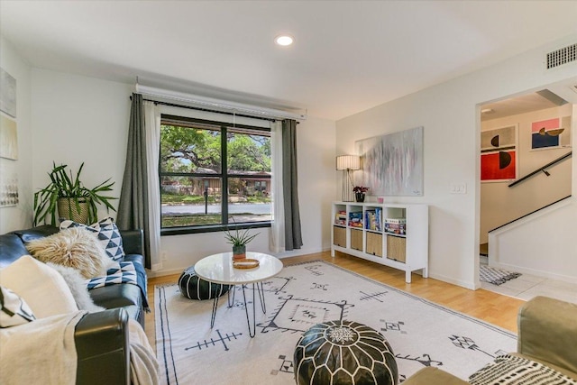living room with wood finished floors, baseboards, and recessed lighting