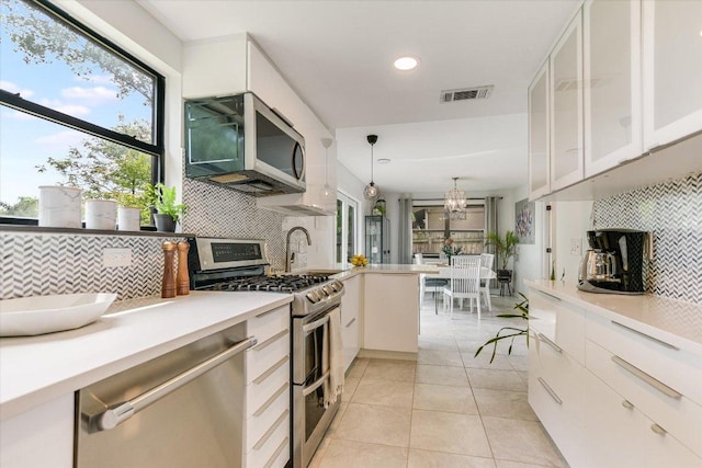 6003 Merriwood Dr, Austin, TX 78745 - kitchen featuring appliances with stainless steel finishes, decorative backsplash, white cabinets, light countertops, and recessed lighting
