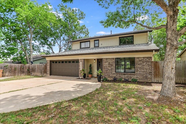 traditional home featuring fence, brick siding, driveway, and a garage