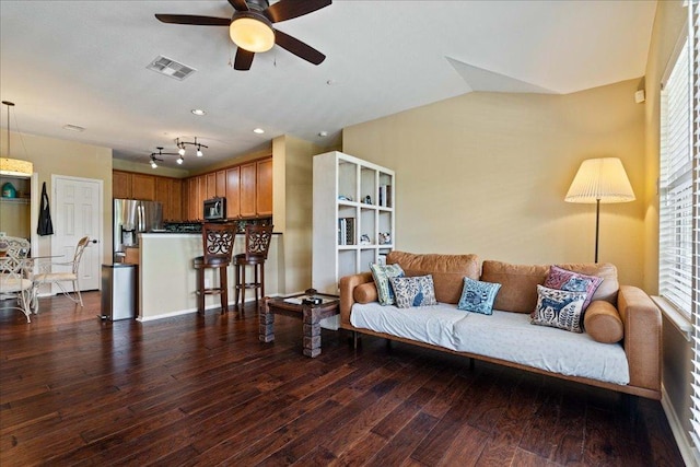 living area with dark wood finished floors, visible vents, and a wealth of natural light