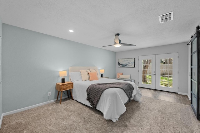 bedroom with visible vents, a barn door, access to exterior, baseboards, and french doors
