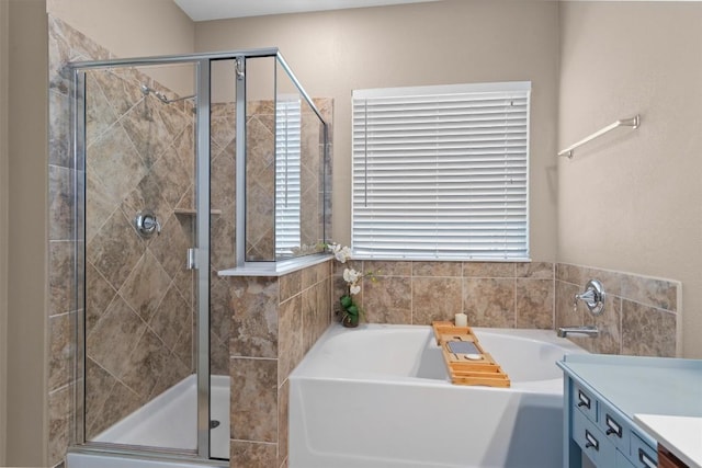 bathroom featuring a garden tub, vanity, and a stall shower