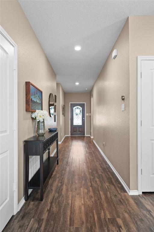 doorway to outside with wood finished floors and baseboards