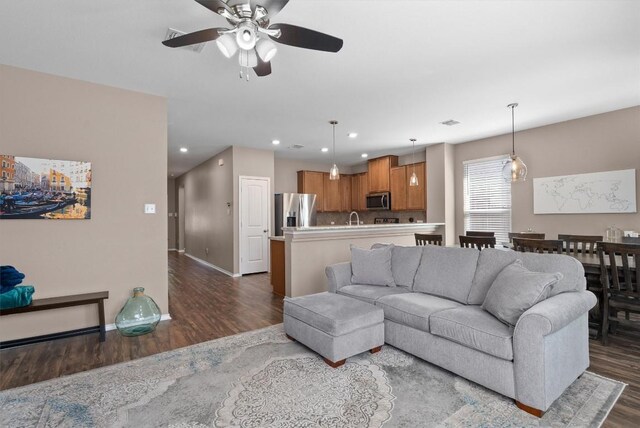 living room featuring recessed lighting, dark wood finished floors, baseboards, and ceiling fan