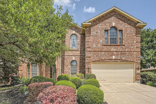 traditional-style home featuring brick siding, a garage, and concrete driveway