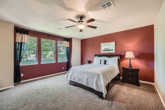 carpeted bedroom with baseboards, a ceiling fan, and visible vents