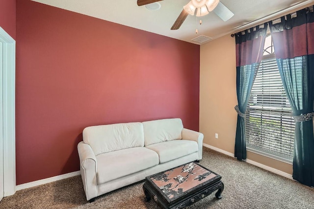 carpeted living area with visible vents, baseboards, and ceiling fan