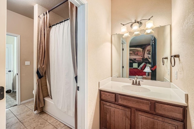 bathroom with tile patterned floors, a textured ceiling, shower / bath combo with shower curtain, a textured wall, and vanity