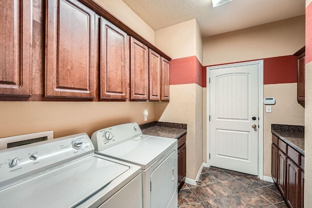 washroom featuring cabinet space, independent washer and dryer, a textured ceiling, and baseboards
