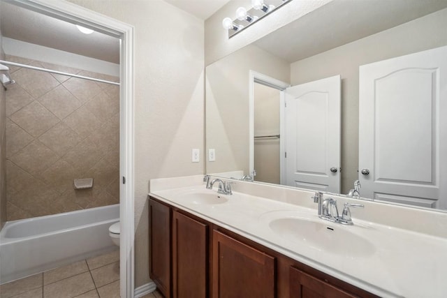 bathroom with double vanity, a sink, tile patterned flooring, and toilet