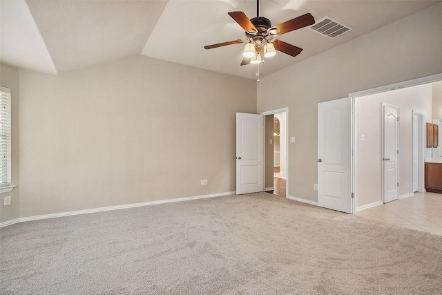 unfurnished bedroom with visible vents, baseboards, lofted ceiling, and light colored carpet
