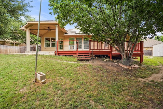 back of property featuring fence, ceiling fan, a yard, and a deck
