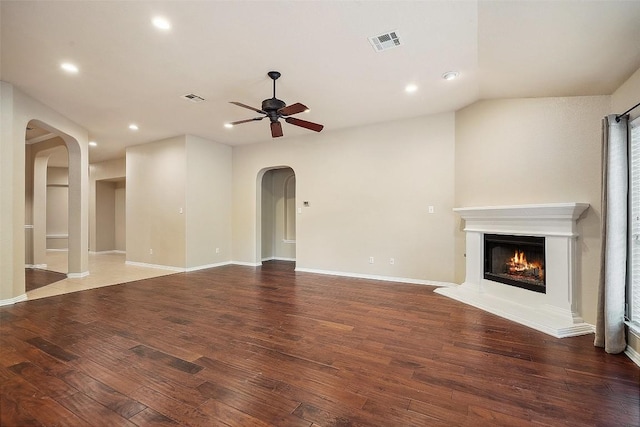 1124 Dyer Creek Pl, Round Rock, TX 78665 - unfurnished living room featuring arched walkways, a ceiling fan, recessed lighting, a warm lit fireplace, and wood finished floors
