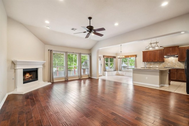 1124 Dyer Creek Pl, Round Rock, TX 78665 - unfurnished living room featuring vaulted ceiling, light wood finished floors, a lit fireplace, recessed lighting, and a ceiling fan