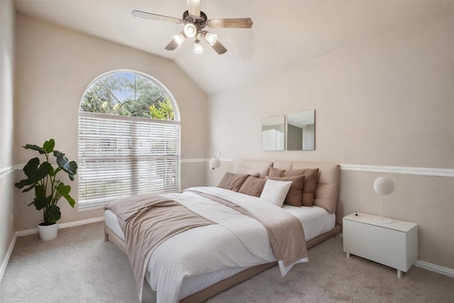 bedroom with light colored carpet, a ceiling fan, vaulted ceiling, and multiple windows